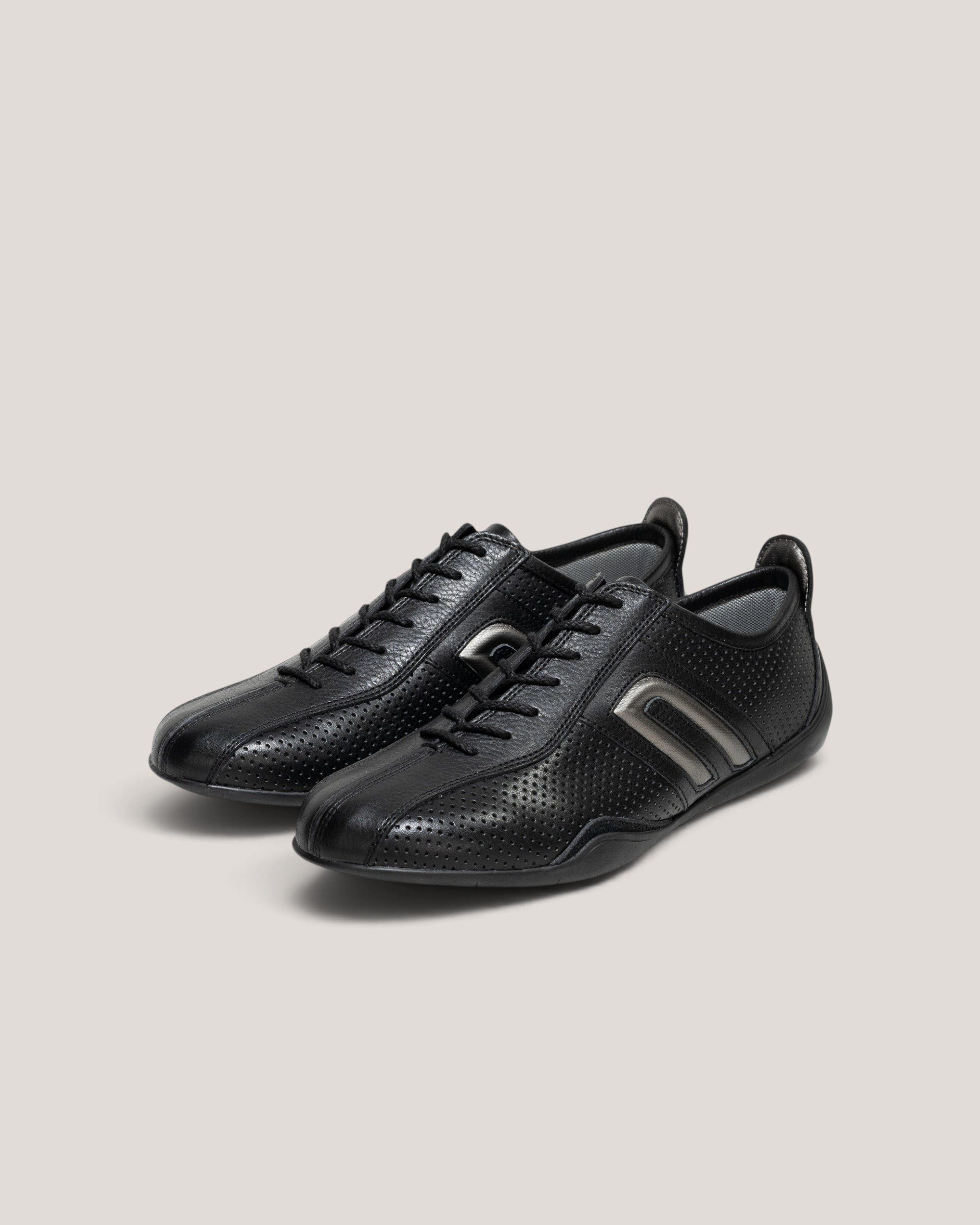 NEGRONI WEB STOREのイデア パンチング ドライビングシューズ。ブラックのパンチングレザーにメタルシルバーのアクセントが施された、通気性の高い3Eワイドラストのレザースニーカー。